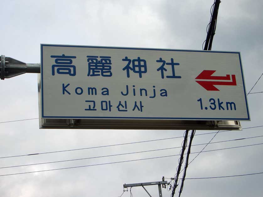 Sign in Japanese, English and Hangul pointing towards the Koma Shrine, Saitama.