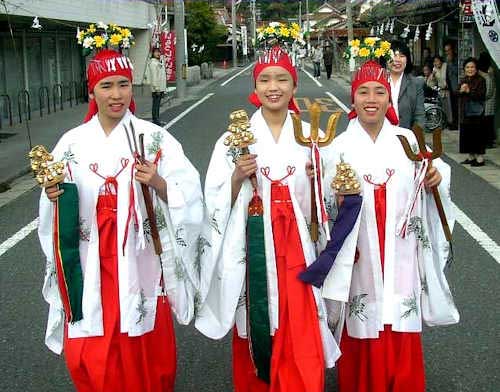 3 young miko in a procession following a festival in a small village.